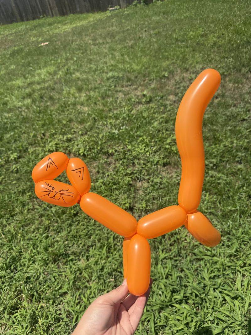 Orange balloon cat sculpture at a Texas party