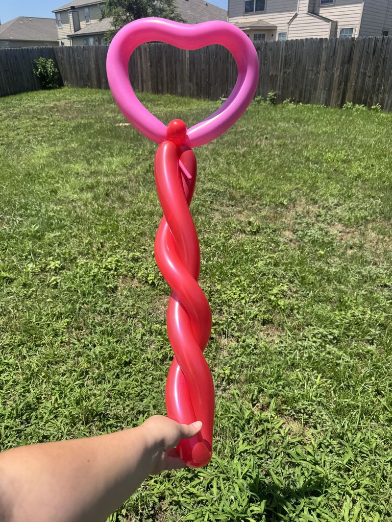 Pink and red balloon heart wand at a Texas kids party