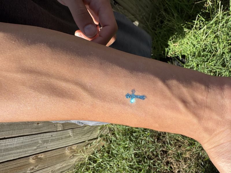 Blue cross glitter tattoo design for party entertainment in Texas